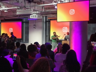 Performance on stage with Instagram branded screens and a full audience